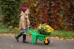 A little girl carrying yellow flower in winter season