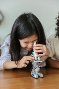 little girl looking into a microscope